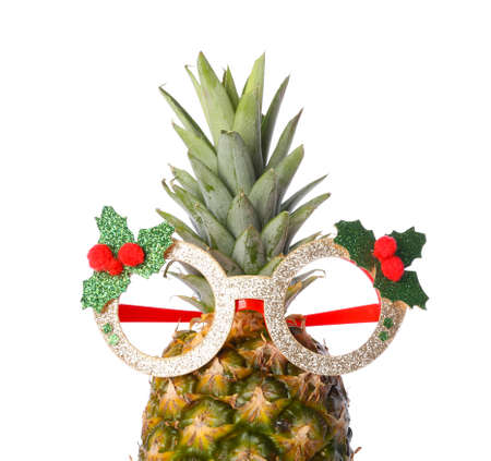 Funny pineapple in Christmas glasses on white background, closeupの写真素材