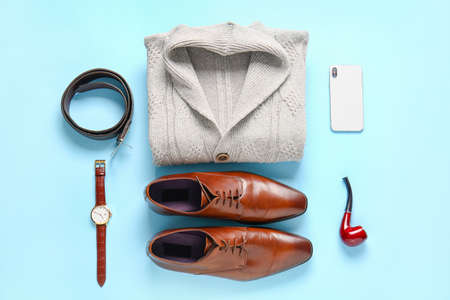 Male sweater, shoes, accessories and mobile phone on color backgroundの写真素材