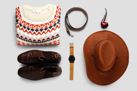 Male sweater, shoes and accessories on light background