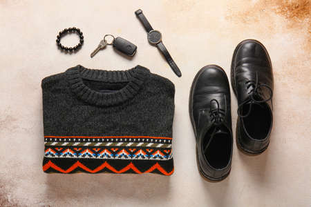 Male sweater, accessories and shoes on grunge background