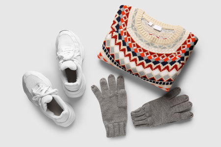 Male sweater, gloves and shoes on light background