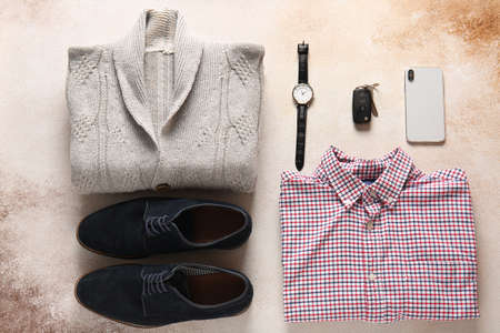 Male clothes, shoes, wristwatch, car key and mobile phone on color backgroundの写真素材
