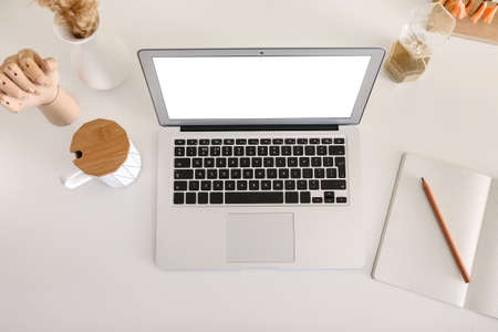 Modern laptop, cup, notebook and stylish decor on light table