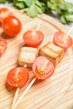 Board with grilled tofu cheese skewers and vegetables, closeupの写真素材