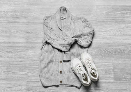 Stylish male sweater and shoes on gray wooden background
