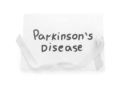 Paper sheet with text PARKINSON'S DISEASE and awareness ribbon on white backgroundの写真素材