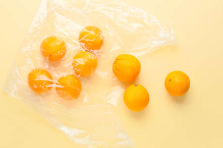 Package with fresh ripe oranges on color backgroundの写真素材