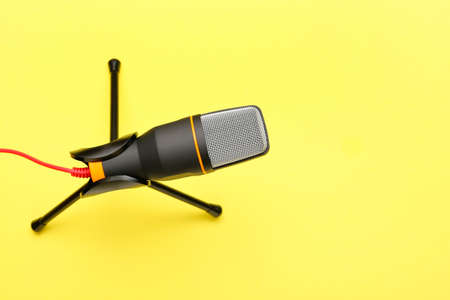 Stand with modern microphone on yellow backgroundの写真素材