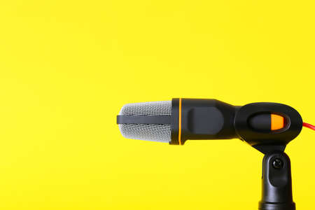 Stand with modern microphone on yellow backgroundの写真素材