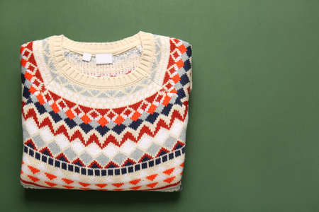 Warm sweater with stylish pattern on green backgroundの写真素材