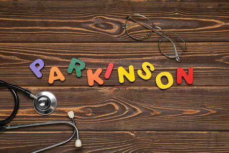 Word PARKINSON with stethoscope and eyeglasses on wooden backgroundの写真素材
