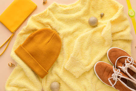 Warm sweater, shoes, accessories and Christmas balls on color backgroundの写真素材