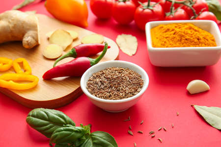 Bowls with spices and vegetables on red backgroundの写真素材