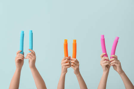 Hands with popular pop tubes on color backgroundの写真素材