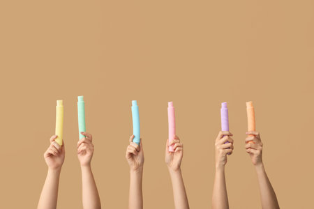 Hands with popular pop tubes on color backgroundの写真素材