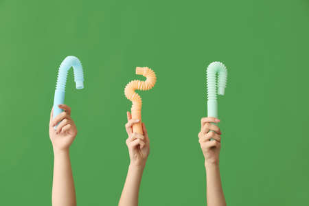 Hands with popular pop tubes on color backgroundの写真素材