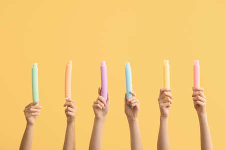 Hands with popular pop tubes on color backgroundの写真素材