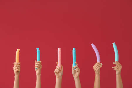 Hands with popular pop tubes on color backgroundの写真素材