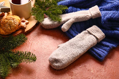 Warm gloves and fir branches on red backgroundの写真素材