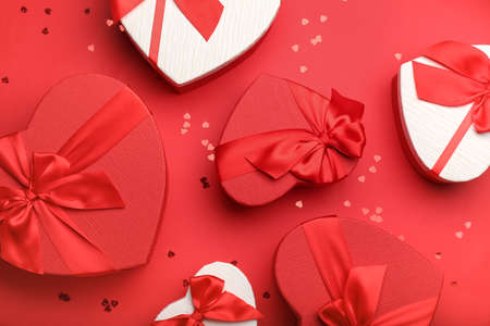 Gift boxes for Valentine's Day and confetti on red background