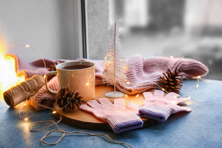 Warm gloves, cup of tea and Christmas lights on windowsillの写真素材