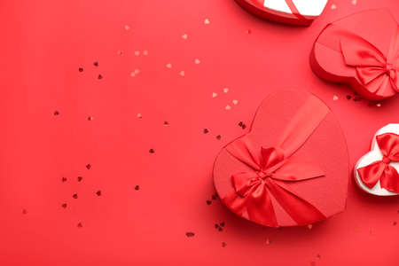 Gift boxes for Valentine's Day and confetti on red backgroundの写真素材