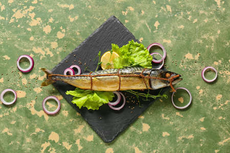 Board with smoked mackerel fish on grunge backgroundの写真素材