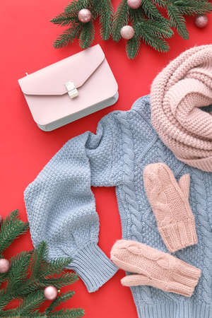 Stylish winter clothes, accessories and Christmas decor on red backgroundの写真素材