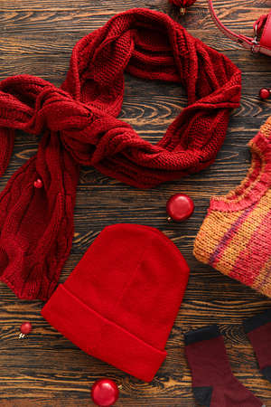 Warm winter clothes and Christmas balls on dark wooden backgroundの写真素材