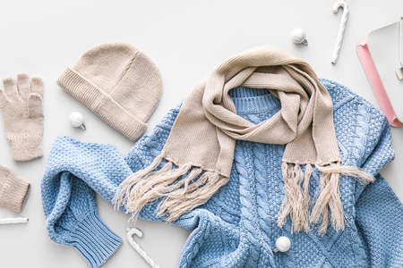 Stylish winter clothes and Christmas decor on light backgroundの写真素材