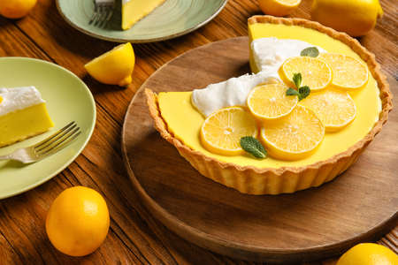 Wooden board with tasty lemon pie on wooden backgroundの写真素材