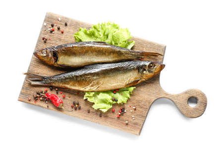 Wooden board with smoked herring fishes on white backgroundの写真素材