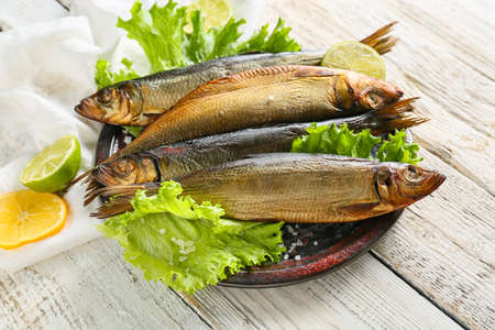 Plate with smoked herring fishes on white wooden backgroundの写真素材
