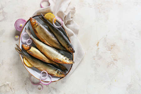 Plate with smoked herring fishes on light backgroundの写真素材