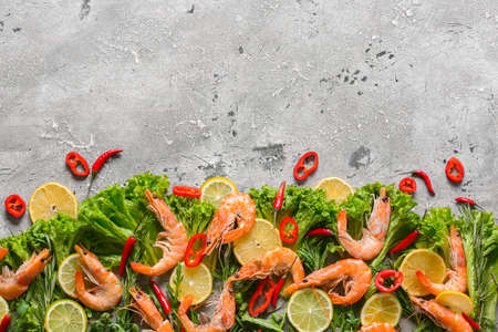 Tasty shrimps with lettuce and lemon on gray backgroundの写真素材