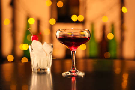 Glass of tasty Manhattan cocktail on table in bar