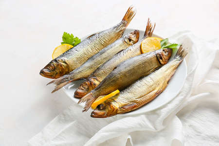 Plate with smoked herring fishes on white backgroundの写真素材