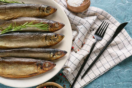 Plate with smoked herring fishes on blue background, closeupの写真素材