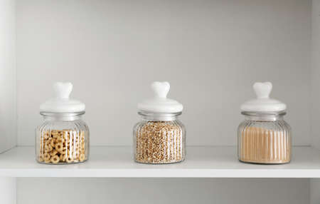Jars of cereals on shelf in kitchen