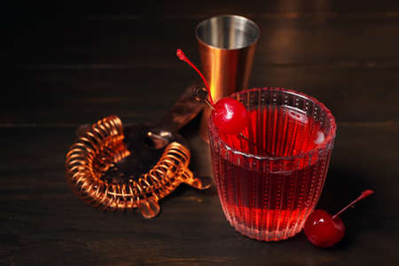 Glass of tasty Manhattan cocktail on dark wooden backgroundの写真素材