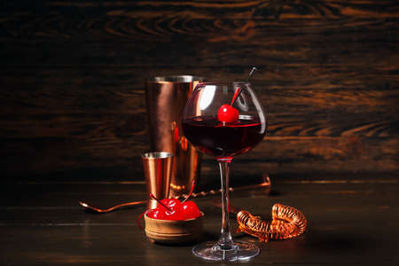 Glass of tasty Manhattan cocktail on dark wooden backgroundの写真素材