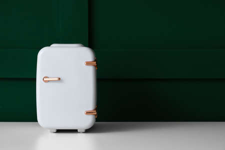 Small cosmetic refrigerator on table near green wallの写真素材