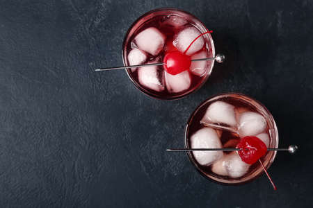 Glasses of tasty Manhattan cocktail on black background