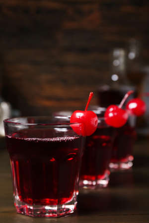 Glasses of tasty Manhattan cocktail on dark wooden backgroundの写真素材