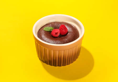 Ramekin with tasty lava cake fondant and raspberry on yellow backgroundの写真素材