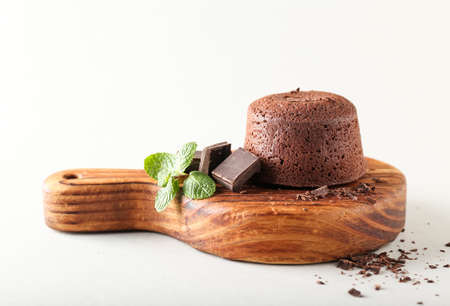 Board with tasty lava cake fondant and mint on white backgroundの写真素材
