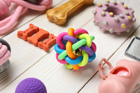 Different pet care accessories on light wooden background, closeup