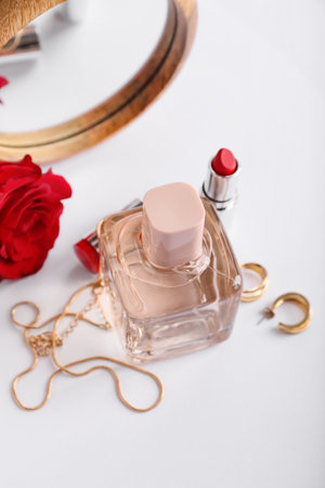 Perfume, lipsticks, rose and accessories on light backgroundの写真素材