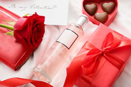 Perfume, chocolate candies and rose for Valentine's day on fabric background, closeupの写真素材