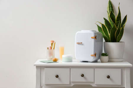 Small cosmetic refrigerator on table in room